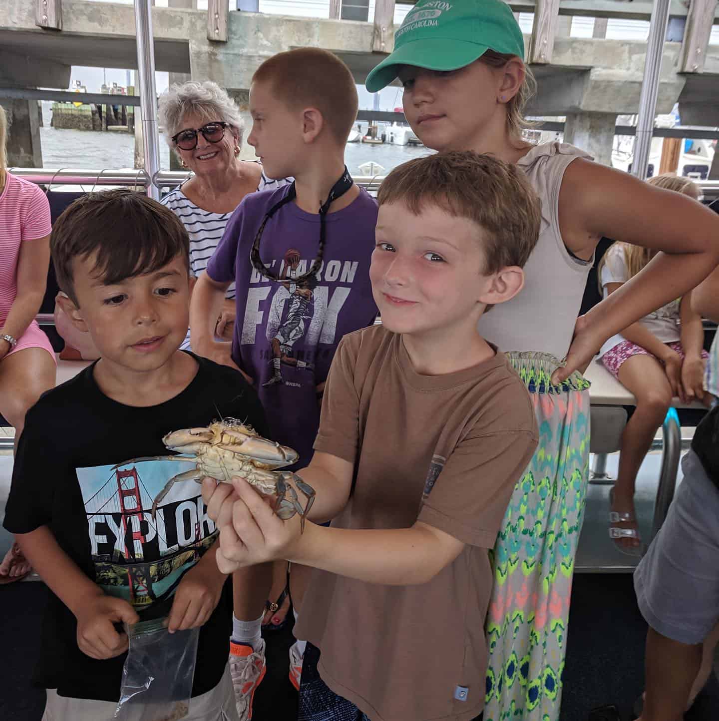 Child holding live crab. Nature boat tours Charleston