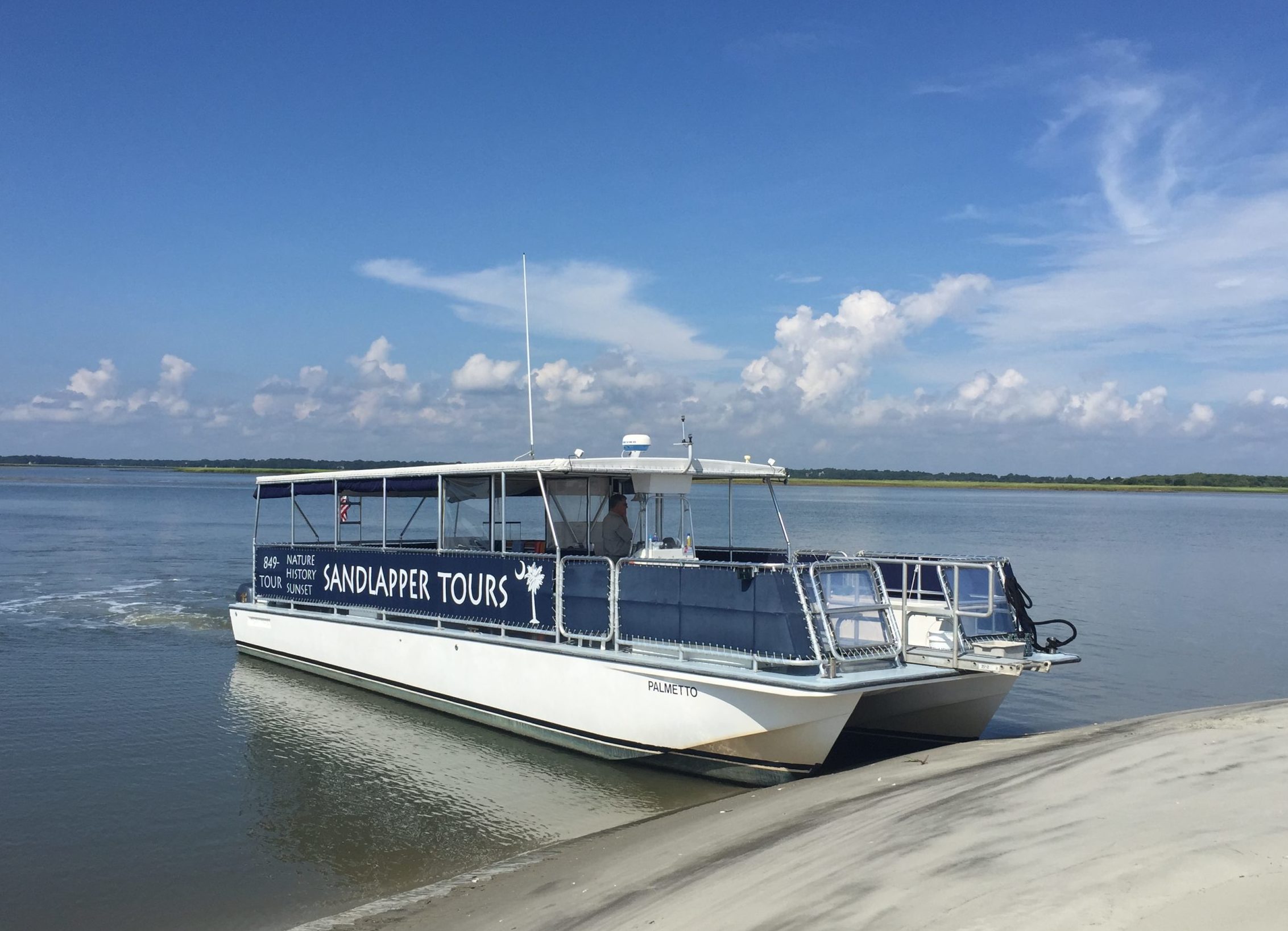 Sandlapper Tours boat docked on the beach. Private charter Charleston, SC