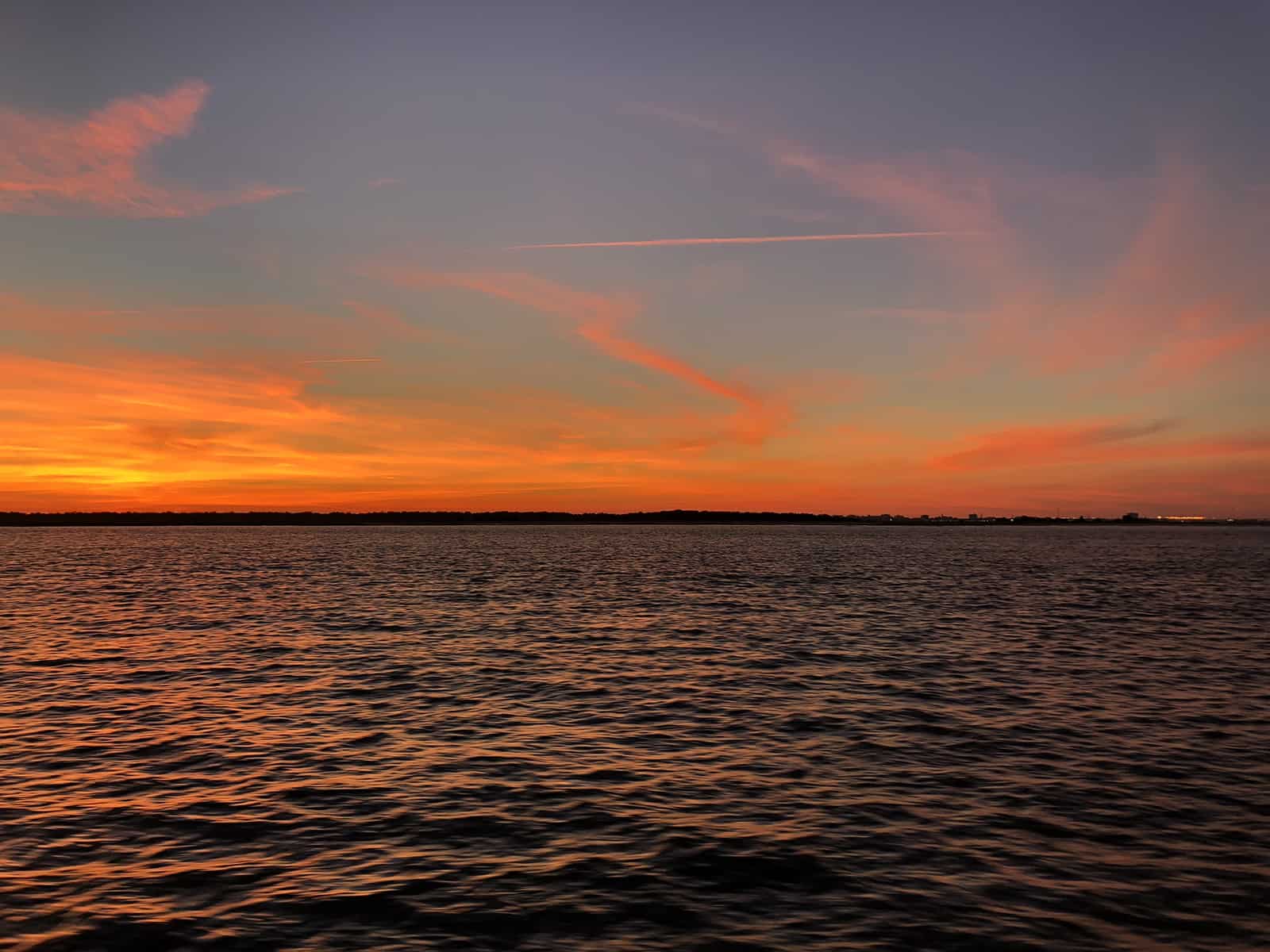 Orange sunset on the water. Sunset dolphin cruise Charleston, SC